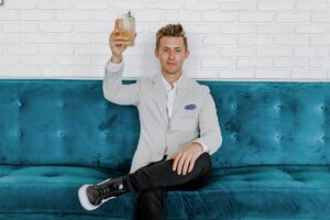 Man holding drink while sitting on a couch